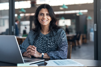 woman smiling with a computer